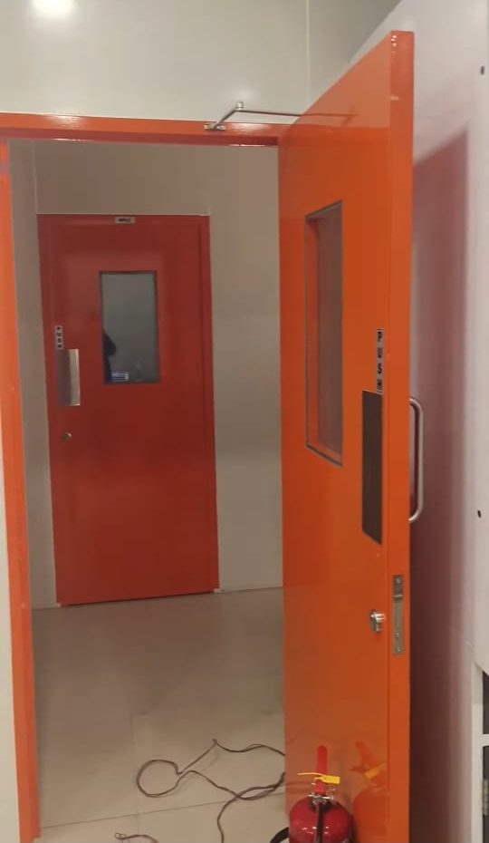 Powder-coated cleanroom doors with vision panels installed by Syntic Products